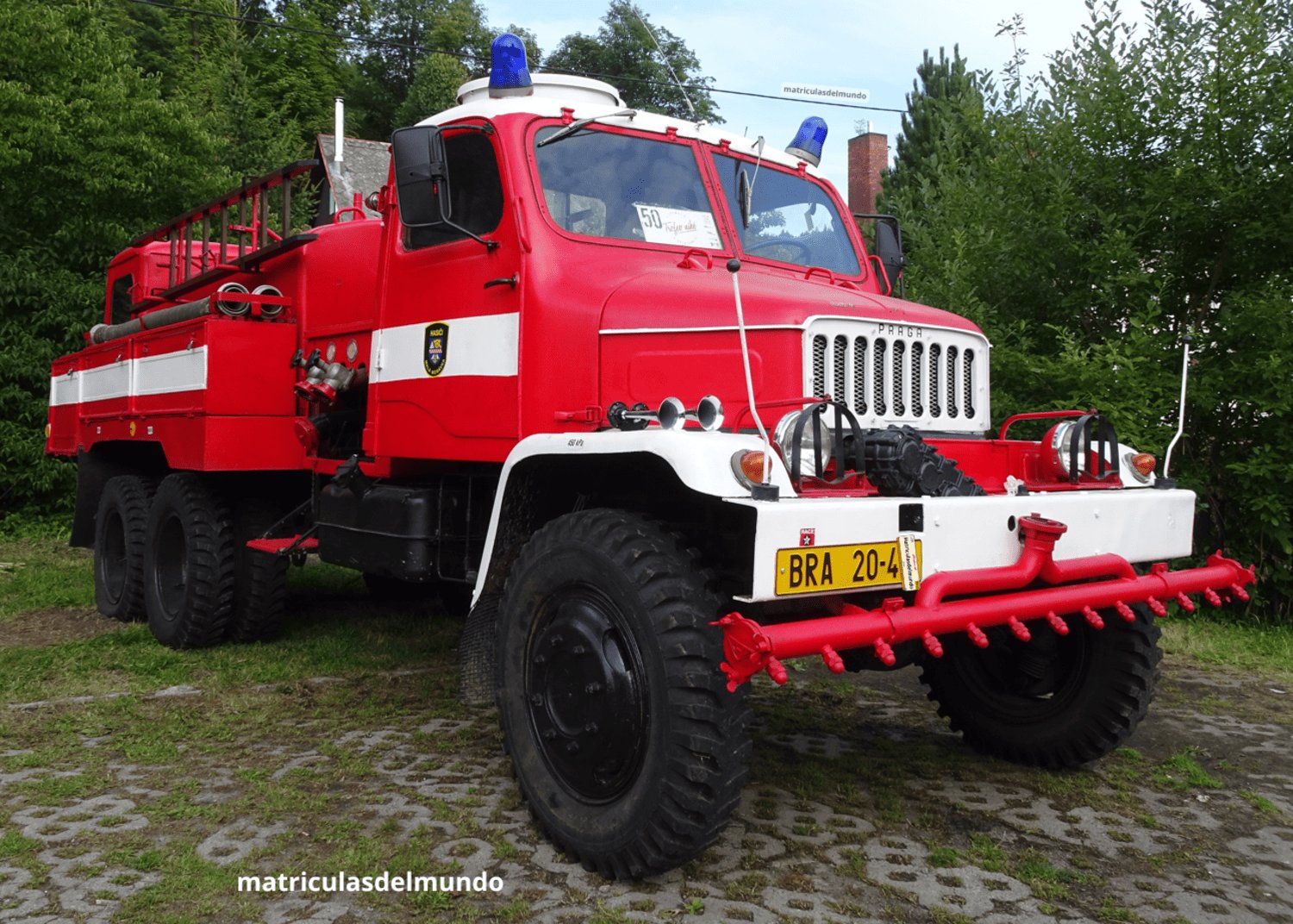Camión Praga v3s de bomberos con matrícula comercial del sistema antiguo aparcado en un jardín