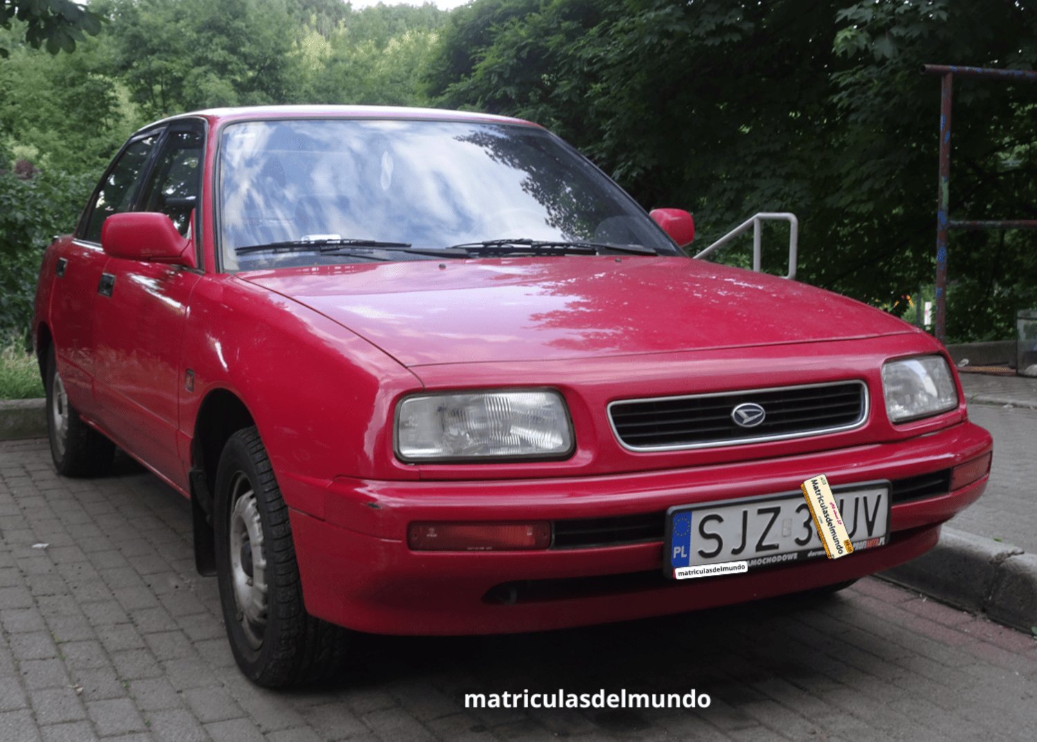Daihatsu rojo sedán con placa de matrícula de Polonia actual aparcado en una calle de la capital