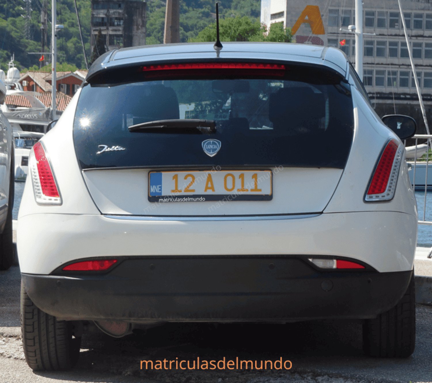 Ejemplo de imagen de coche de la marca Lancia con matrícula diplomática junto al mar
