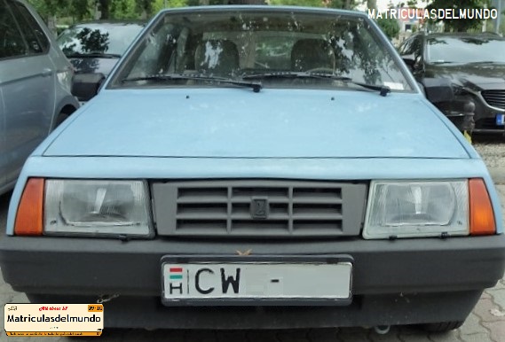 Lada de color azul con matrícula de Hungría y con bandera húngara aparcado en una calle de una ciudad del centro del país y letras CW
